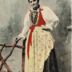 Foto de cartão-postal do início do século XX mostra mulher em traje típico da região de Val di Fassa - Trentino